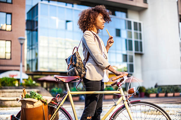 girl with bike is having a breadstick as a snack on the go