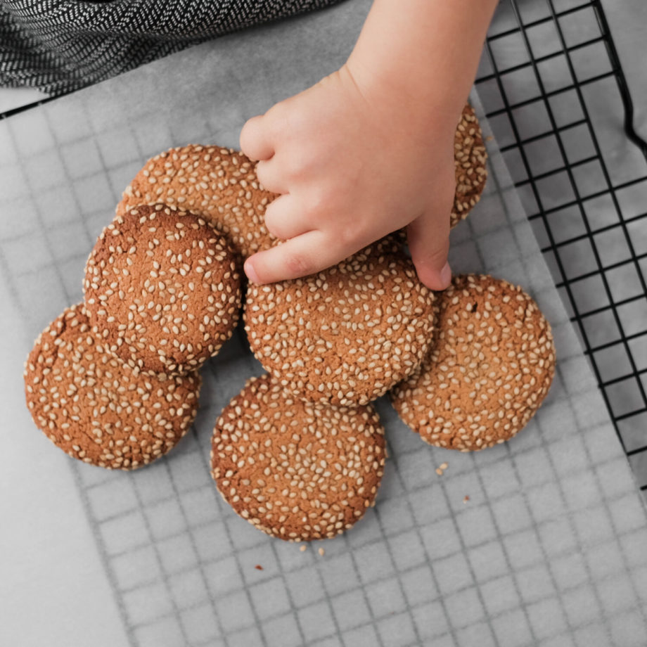 a child is picking cookies from the oven tray